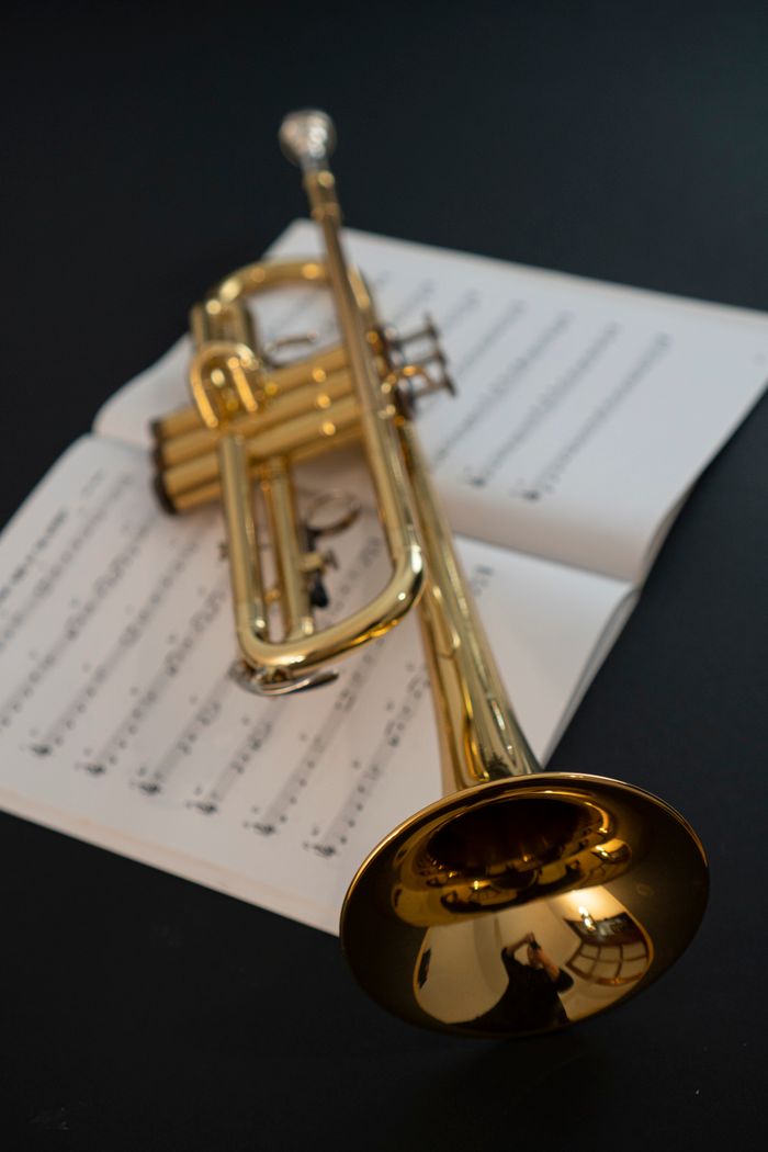 A shiny golden trumpet lying on top of open music sheets, creating a classic musical scene.